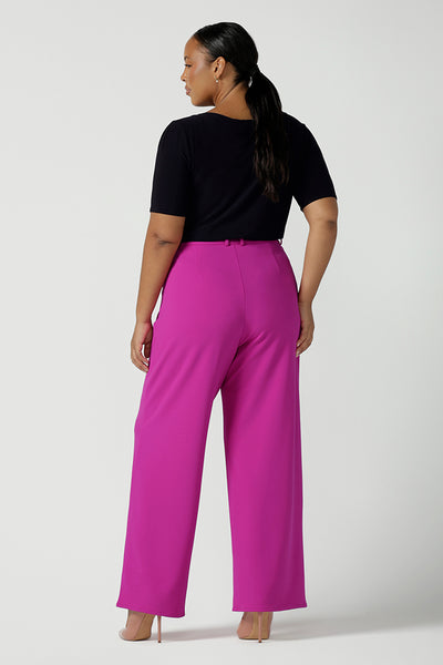 Back view of a size 16 Woman wears the Drew Pant in Fuchsia. A high waist tailored pant with matching suit blazer. Made in Australia for women size 8 - 24.Styled back with a black Ziggy top. 