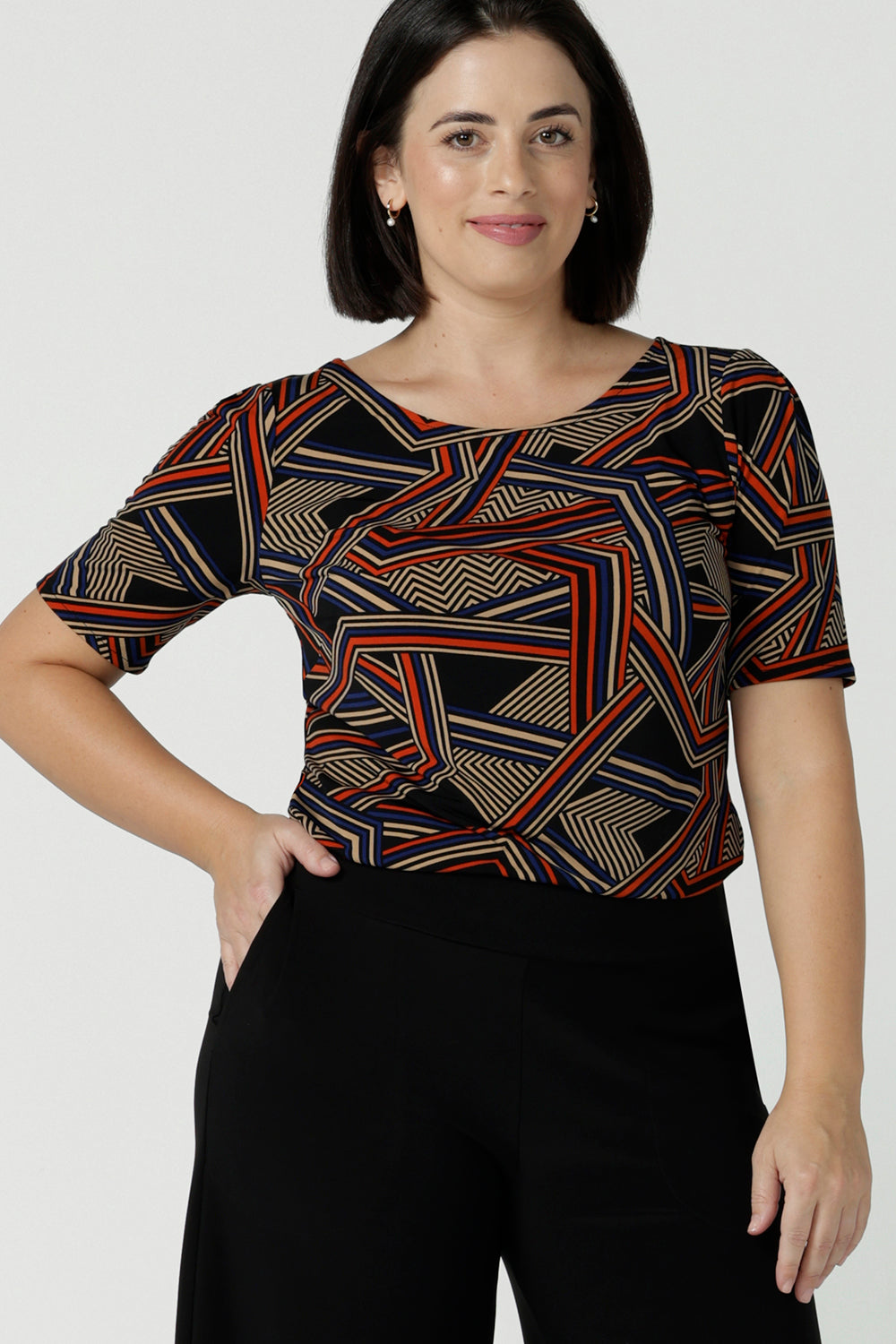 Size 10 woman wears the Ziggy Top in Trixe, a jersey boat neckline top and short sleeves. Conservative boat neckline and softly curved hem. Easy care jersey and size inclusive for petite to plus size. Made in Australia for women size 8 - 24.