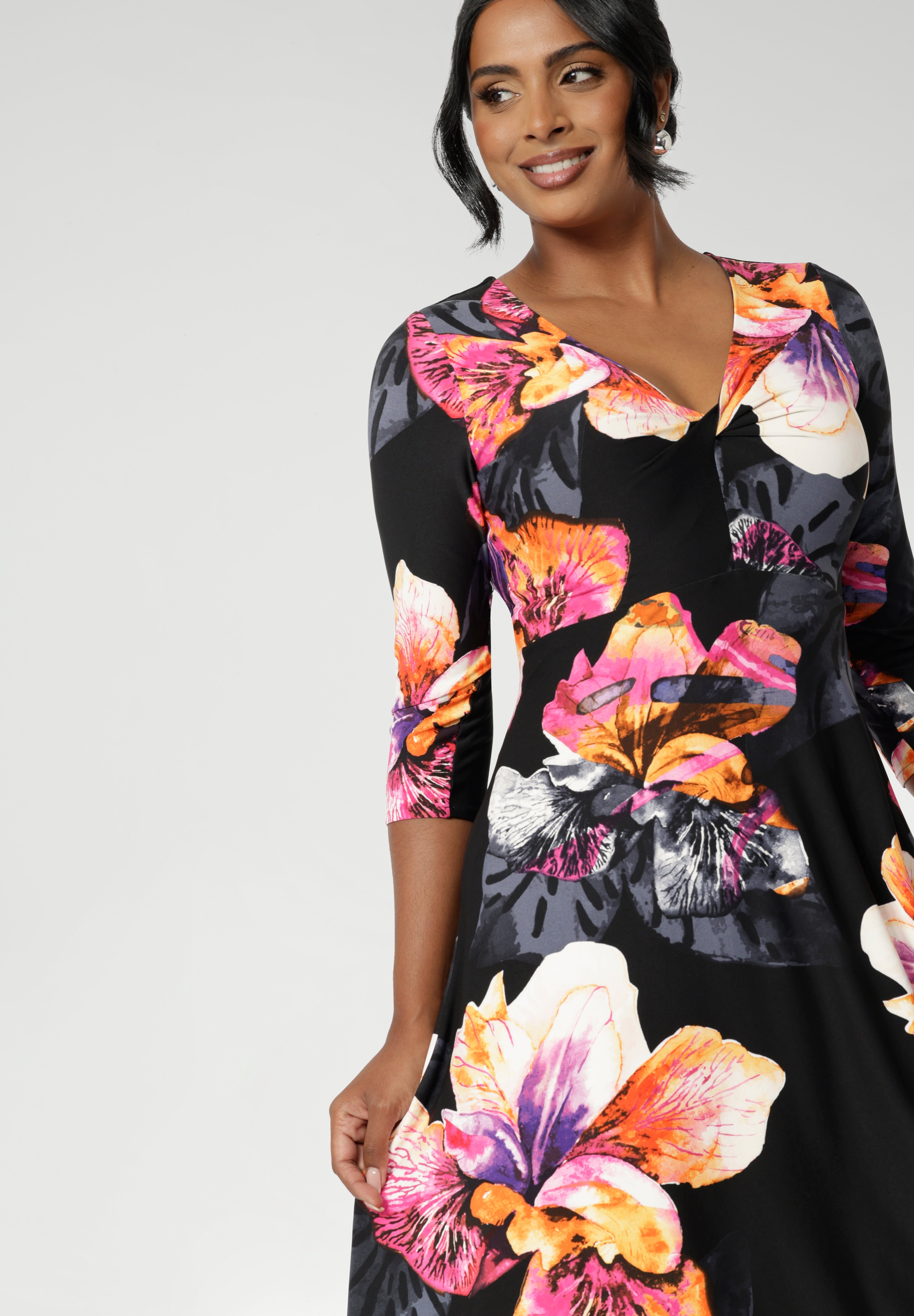 Highlighting Australian fashion brand, Leina & Fleur's great collection of midi dresses, a size 10 woman wears midi length black wrap dress with 3/4 sleeves.