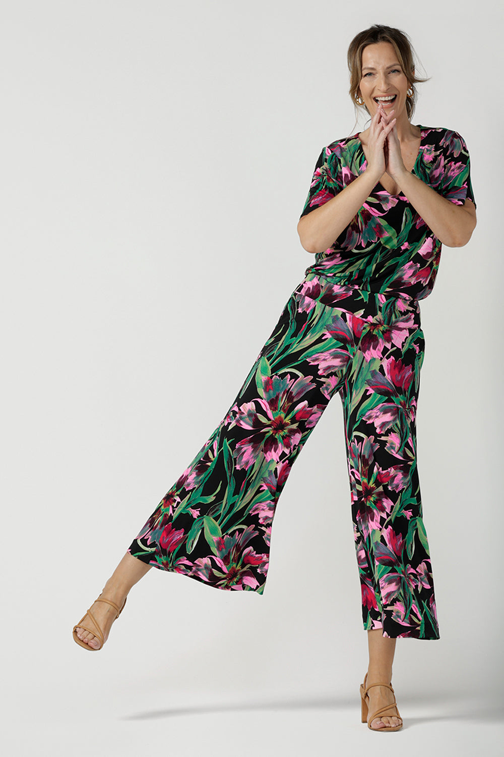 A size 10, 40 plus woman wears printed jersey, wide leg pants as a jumpsuit look wth floral print, flutter sleeve jersey top. Pull-on pants with a deep waistband, the cropped, culotte legs make great summer pants that work for petite heights as well as taller women. Shop pants online in sizes 8 to 24.
