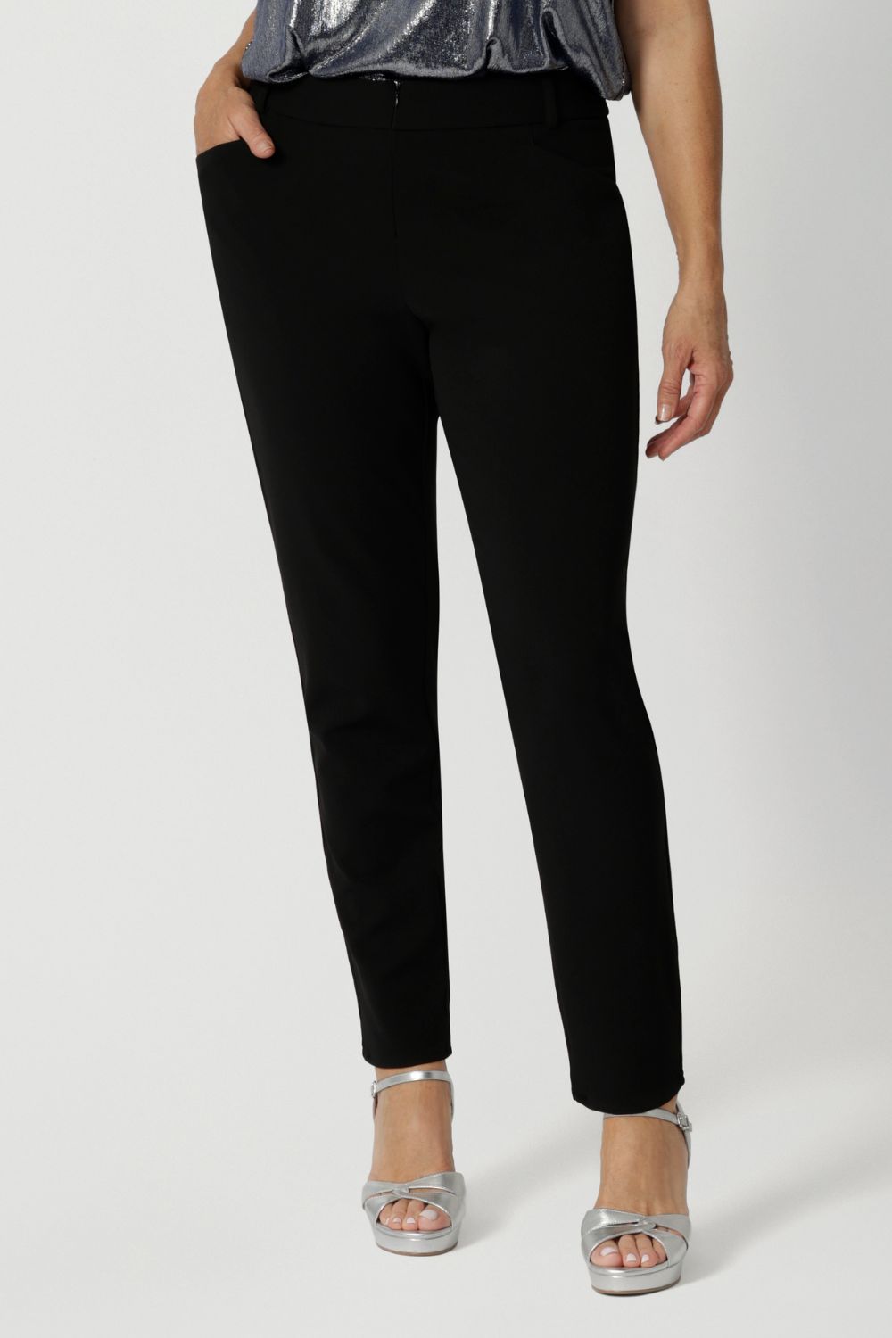 A size 12 woman wears the Corbin Pant in Black Scuba Crepe. A tailored scuba crepe pant wth a cropped length. Comfortable and easy care pants made in Australia for women size 8-24. 