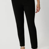 A size 12 woman wears the Corbin Pant in Black Scuba Crepe. A tailored scuba crepe pant wth a cropped length. Comfortable and easy care pants made in Australia for women size 8-24. 