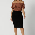 An off-the-shoulder top for summer, this slinky jersey top is a good top for over 40s style. Shown on a size 12 woman, this easy-care top is worn with a knee length, tube skirt.  Made in Australia by Australian and New Zealand women's clothing brand, Leina & Fleur. Shop petite to plus size tops online for summer.