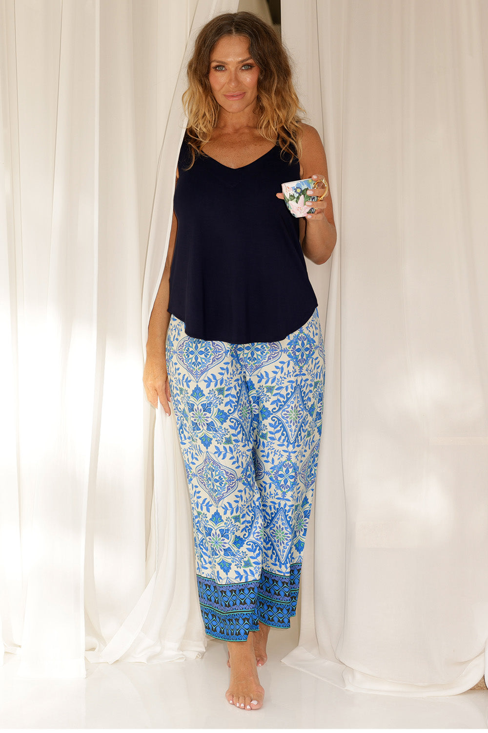 An over 40s woman wears blue and white print pyjama set in size 12. Some of the best pyjamas for menopause, these womens pyjamas are made in bamboo jersey and modal, both breathable and thermo-regulating, they are best cooling materials for night sweats. Shop dressing gowns and pyjama sets for women online in sizes 8 to 24.