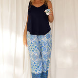 Showing a pretty pyjama set that's great for over 40s women, a size 12 woman wears straight leg pyjama pants with blue and white print and a navy blue bamboo jersey cami top with wide shoulder straps. Thermo-regulating and breathable, these pajamas pants with drawstring ties and good pyjamas for night sweats and hot flushes. Shop the set online at L&F Australia in sizes 8 to 24.