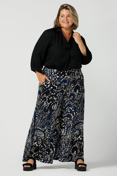 A curvy, size 16 woman wears animal printed wide leg pants with pockets. These pull-on, easy care pants are comfortable for your everyday capsule wardrobe. Shop these Australian-made wide leg trousers online in sizes 8 to 24, petite to plus sizes.