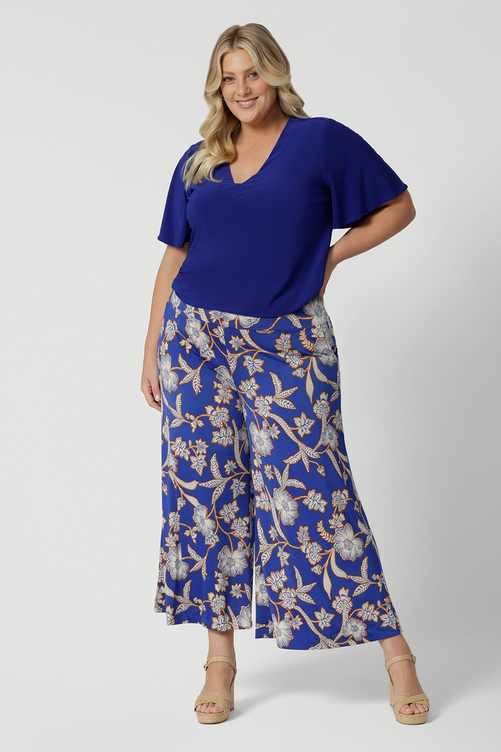 Wide leg pants for summer don't come much better than this! Worn by a size 18 , curvy woman, these plus size wide leg pants are in easy care jersey with a blue, caramel and white floral print. Made in Australia by Australian and New Zealand women's clothes brand, Leina and Fleur. Shop wide leg pants in petite to plus sizes.