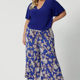 Wide leg pants for summer don't come much better than this! Worn by a size 18 , curvy woman, these plus size wide leg pants are in easy care jersey with a blue, caramel and white floral print. Made in Australia by Australian and New Zealand women's clothes brand, Leina and Fleur. Shop wide leg pants in petite to plus sizes.