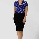 Woman wears V-neckline Emily top in Cobalt Blue spot. Short sleeve with V-neckline. Pleat front and made in Australia for women size 8 -24. 