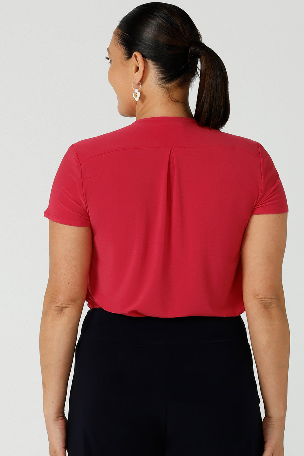 Back view of woman wearing fuchsia raspberry Emily top with v-neck and pleat front neckline. A great work to weekend top with short sleeves. Made in Australia for women size 8 - 24.