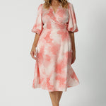 Showing a good dress for over 40s women, this silky wrap dress has an orange spot print and 3/4 lantern-shaped sleeves. Made in Australia by women's clothing brand, Leina & Fleur, wear this 3/4 sleeve wrap dress for wedding guest outfit and summer event  wear. Shop this summer wedding guest and event wear outfit online in sizes 8 to 24.