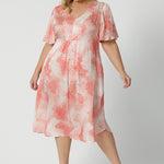 Showing a good dress for plus size women, this silky flutter sleeve dress in viscose fabric has an orange spot print. Made in Australia by women's clothing brand, Leina & Fleur, this lightweight summer dress is breathable. Shop this summer wedding guest and event wear outfit online in sizes 8 to 24.