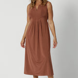 Showing a dress for 0ver 40s women, this sleeveless clay coloured dress in slinky jersey fabric is perfect as an off duty summer dress. Made in Australia by Australian and New Zealand women's clothing brand, Leina & Fleur. This midi-length empire line dress is available in sizes 8 to 24.