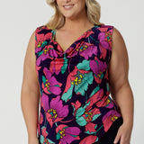 Showing a summer top for curvy women, a size 18, plus size women wears a cowl neck jersey top. This sleeveless top has a bold floral print - great for corporate wear as well as casual wear. Made in Australia by Australian and New Zealand clothing brand, Leina & Fleur, shop this top in petite to plus sizes. 