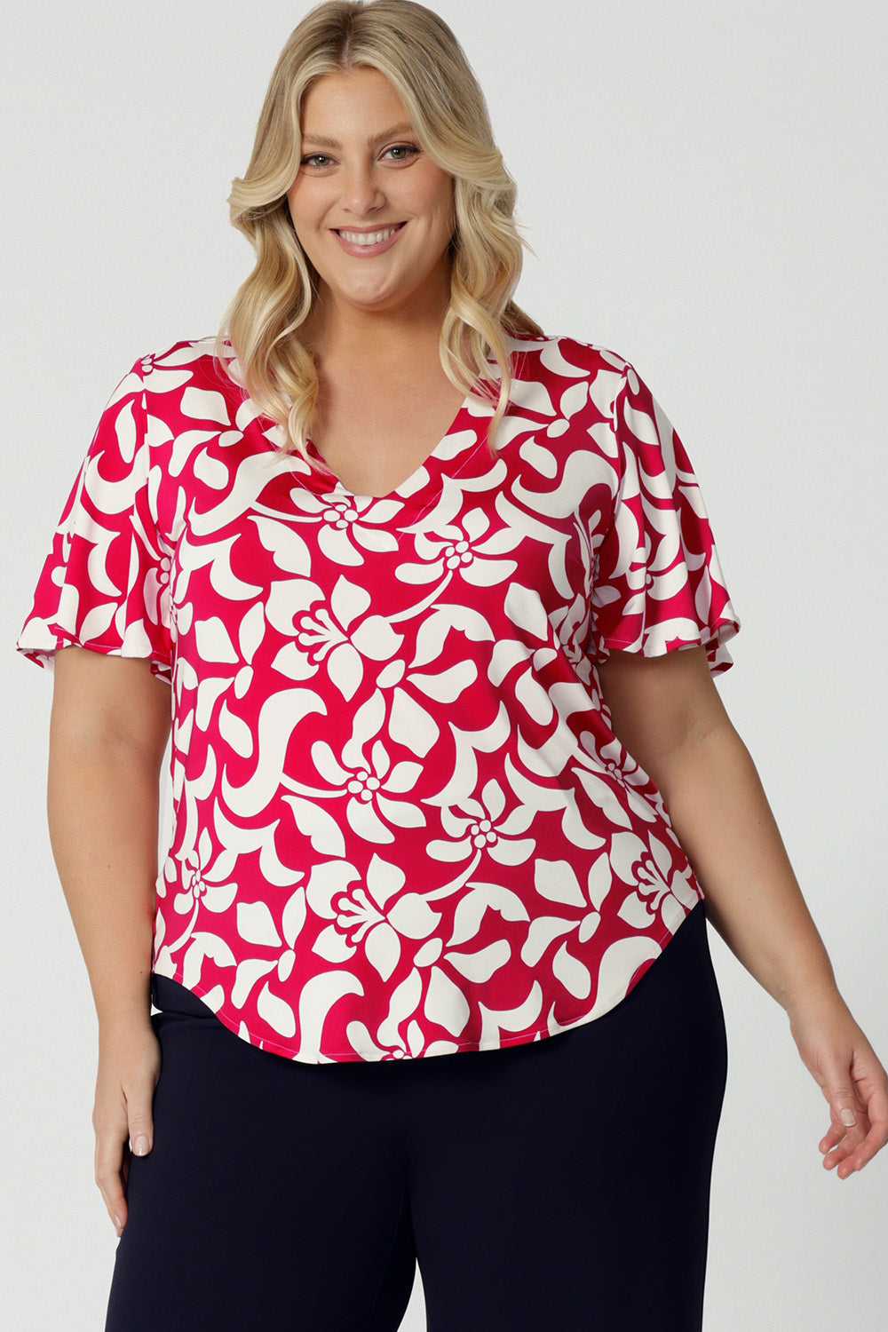 This summer top is the perfect blend of comfort and style, featuring delicate flutter sleeves that add a touch of femininity and movement. The top comes in a sophisticated red base with a striking ivory floral design. Crafted from high-quality dry-touch jersey, the fabric offers a soft, breathable feel that’s ideal for warmer weather, keeping you cool and comfortable throughout the day. Shop the Lila Top in sizes 8-24.