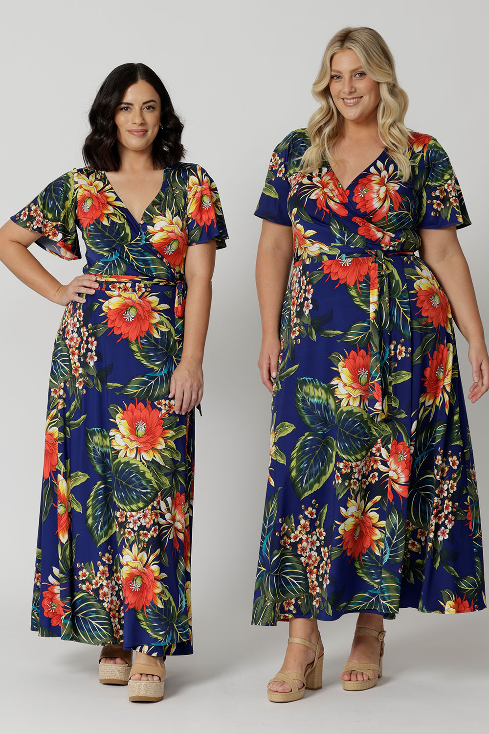 Two women of different heights wearing maxi dress. Long wrap dress is stocked in petite and plus sizes. This resort ready dress is made from slinky jersey floral fabric. Resort style dress perfect for travel as the fabric is wrinkle resistant. Leina & Fleur stock sizes from 8 to 24.