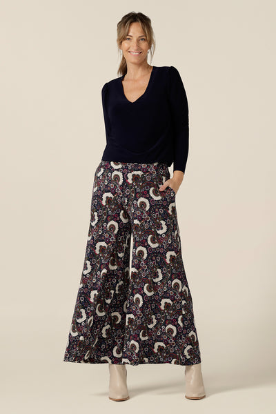 A size 10, 40 plus woman wears pull-on wide leg jersey pants with a long sleeve, V-neck top in Navy blue by Australian and New Zealand women's clothing brand, L&F. Comfortable trousers for workwear and weekend wear, these printed pants are made in Australia in sizes 8 to 24.