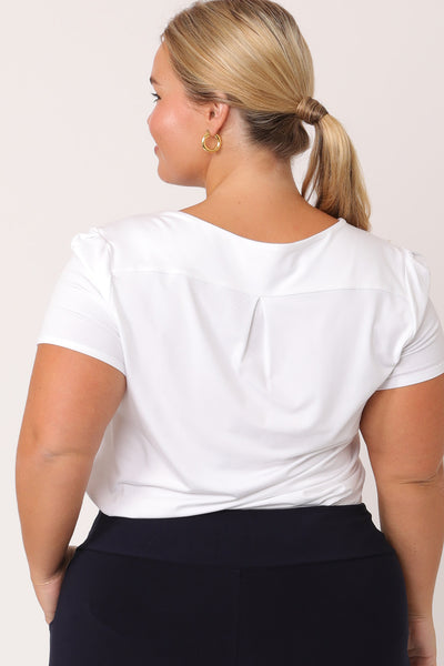 Back view of a petite woman with curve wearing a round neck, short sleeve white bamboo jersey top. Great as a comfortable work top, this plus size top is a classic top with tailored details to elevate your workwear capsule wardrobe.