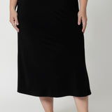 Made from soft-touch black jersey fabric, it feels luxuriously smooth against the skin while offering all-day breathability and ease. The bias-cut design creates natural shaping, gently skimming your curves for a flattering, feminine silhouette without being restrictive. Worn on size 18 woman on the go, styling her midi skirt with white t-shirt & sandals. 