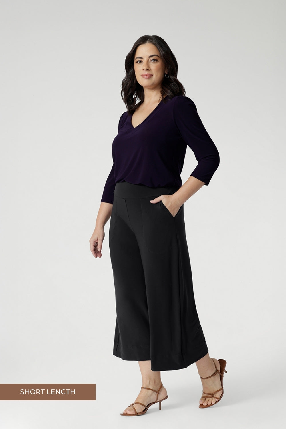 The Bradley Culotte in Charcoal is the ultimate combination of style, comfort, and practicality for your workwear wardrobe. Petite height women wears the short length culottes, paired with amethyst v neck top and brown kitten heels.