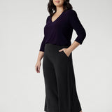 The Bradley Culotte in Charcoal is the ultimate combination of style, comfort, and practicality for your workwear wardrobe. Petite height women wears the short length culottes, paired with amethyst v neck top and brown kitten heels.