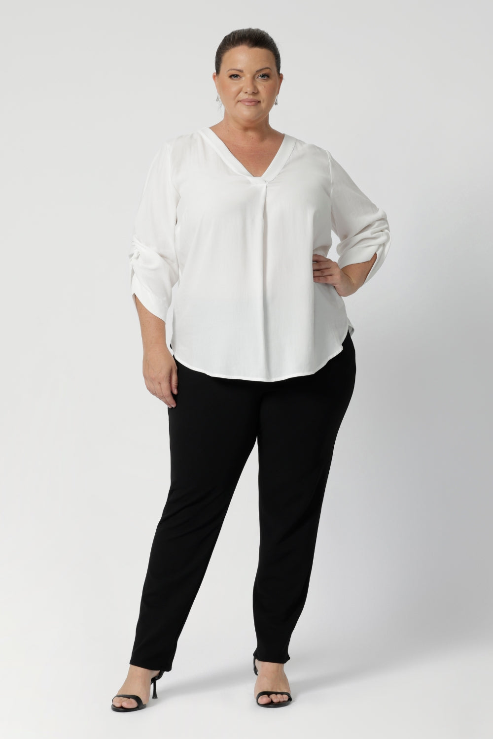 Image of plus sized woman wearing black work wear pants. The Corbin Pant is made of stretchy black Scuba Crepe fabric. This off duty pant style is breathable and has a matching black blazer to complete the full suit look.  Made in Australia by Leina & Fleur, a woman's clothing brand that stocks sizes 8-24.