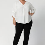 Image of plus sized woman wearing black work wear pants. The Corbin Pant is made of stretchy black Scuba Crepe fabric. This off duty pant style is breathable and has a matching black blazer to complete the full suit look.  Made in Australia by Leina & Fleur, a woman's clothing brand that stocks sizes 8-24.