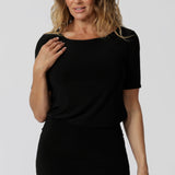 An elegant boat neckline crowns the Ziggy Top. Short sleeved workwear top is close to the arms to elbow length. Bust darts aid the fit of her slender-cut body as it glides down to cover the hips, finishing with a curved hemline.