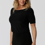 Women's workwear top is worn by size 12 model. An elegant boat neckline crowns the Ziggy Top. Short sleeved workwear top is close to the arms to elbow length. 