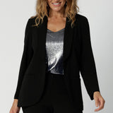 40 year old womans wears tailored black blazer made of soft stretch scuba crepe fabric. Easy care blazer is a staple for any wardrobe. Black work wear blazer provides the perfect blend of work wear and off-duty style. Australia made clothing brand Leina & Fleur. Shop Soft Suiting in sizes 8-24. 