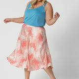 A good wedding guest outfit for plus size women,  a curvy, size 18 woman wears orange-red polka dot print culottes in luxurious Italian viscose fabric. Made in Australia by women's clothing brand, Leina & Fleur, these curve culottes are worn with a plus size cami top in mineral blue. Shop this summer wedding guest and event wear outfit online in sizes 8 to 24.