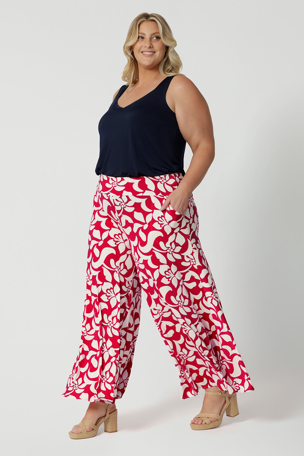 Wide-leg silhouette offers a flattering, relaxed fit that flows effortlessly, making them perfect summer season. Palazzo pants feature a bold red base adorned with a stunning ivory floral design.  Crafted from high-quality dry-touch jersey fabric. The lightweight fabric ensures you stay cool and comfortable while maintaining a polished appearance. Caspian Palazzo Pant is stocked in sizes 8-24.