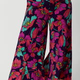 A curvy size 18 woman wears the Caspian Palazzo pant in a bright floral print. In soft and lightweight jersey this pant features side pockets and a flared leg opening. Made in sizes 8 to 24 by Australian fashion brand Leina & Fleur.