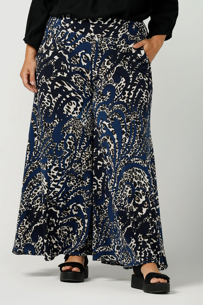 Close up of a curvy, size 16 woman wears animal printed wide leg pants with pockets. These pull-on, easy care pants are comfortable for your everyday capsule wardrobe. Shop these Australian-made wide leg trousers online in sizes 8 to 24, petite to plus sizes.