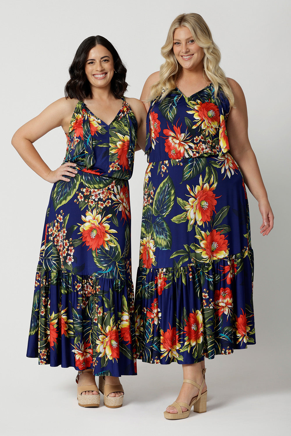 Full body image of 2 woman of different heights wearing the Darci Dress in Bahagia. Floral halter dress is stocked in petite and plus sizes. This easy care dress is made from slinky jersey fabric.This resort style dress is perfect for travel as the fabric is wrinkle free. Leina & Fleur is a woman's brand that stock sizes from 8 to 24.