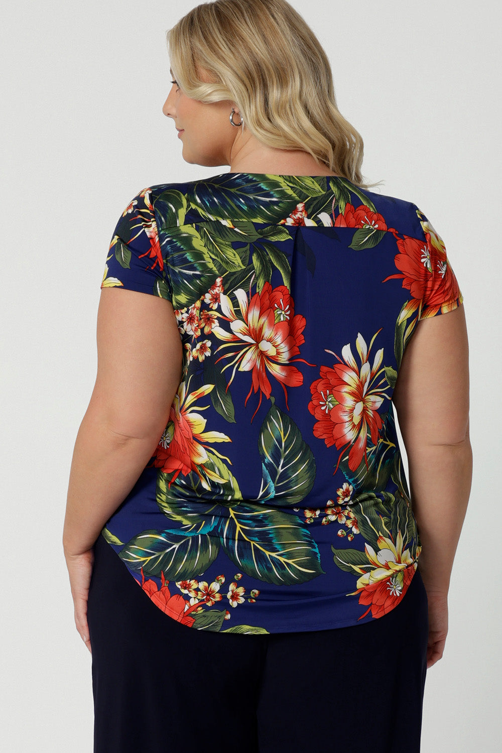 Back view image of plus sized model wearing floral top. Easy care top is made of slinky jersey that is crease-resistant perfect for travel. Comfortable fir top is flattering and relaxed for all-day travel wear. Leina & Fleur stock sizes 8-24. 