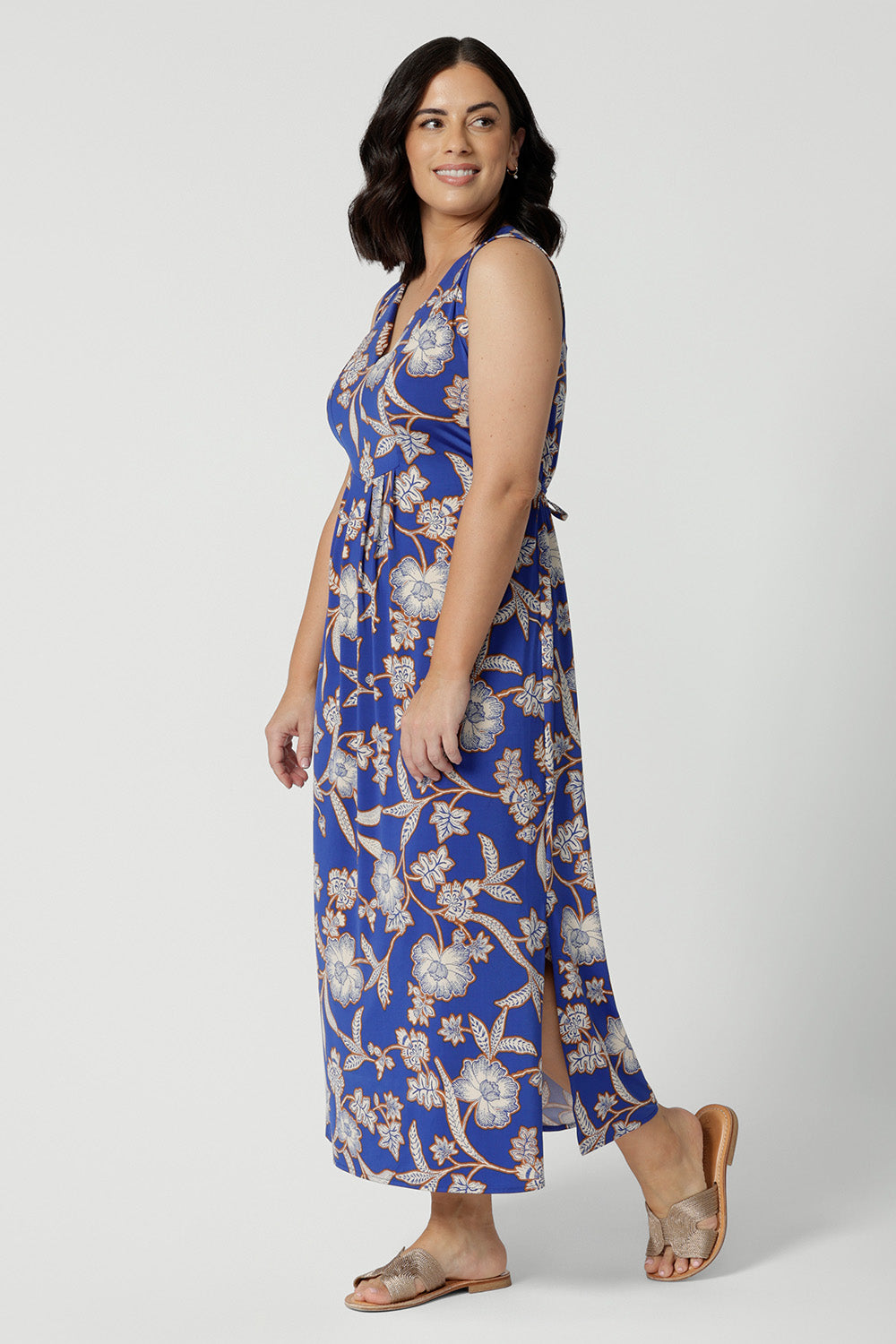 Side view of petite-friendly sleeveless floral print dress in slinky jersey fabric, designed by Australian and New Zealand women's clothing brand, Leina & Fleur. This midi-length summer dress features an empire line cut for a flattering fit, available in petite sizes.