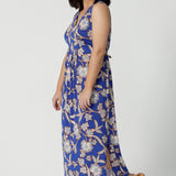 Side view of petite-friendly sleeveless floral print dress in slinky jersey fabric, designed by Australian and New Zealand women's clothing brand, Leina & Fleur. This midi-length summer dress features an empire line cut for a flattering fit, available in petite sizes.