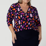 Size 18 curvy woman wears the Jaime top in Palette. A brush stroke inspired abstract print on a navy base with fuchsia, red, orange and pink spots. A v-neck pleat front top great for work to weekend. Comfortable jersey and easy care. Made in Australia for women size 8 - 24.