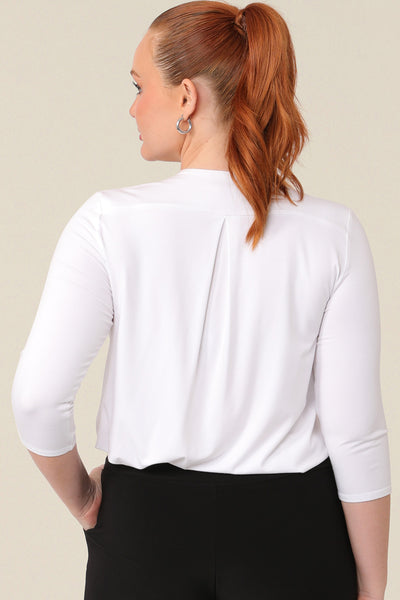 Back view of a great top for curvy women. This white bamboo jersey top is tailored with a pleat below the V-neck and at the back shoulder yoke. Lightweight and breathable, this 3/4 sleeve top makes a comfortable work top, looking classic under workwear jackets and suits. A classic top, this white jersey top is good for casual wear and travel capsule wardrobes too. shown on a curvy, mid size woman, this top is also available in petite and plus sizes online at women's clothing brand, Leina & Fleur. 