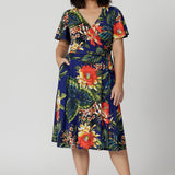 Petite model wears functioning wrap dress. Flattering silhouette suitable for various occasions such as resort wear, travel wear and spring weddings. Woman's clothing brand Leina & Fleur stock sizes from 8-24. Shop this summer ready dress in petite sizes and plus sizes.