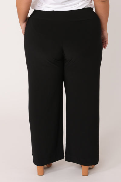 Back view of straight, wide-leg black pants in petite length. These petite work pants are comfortable in pull-on jersey fabric and made in Australia in sizes 8 to 24