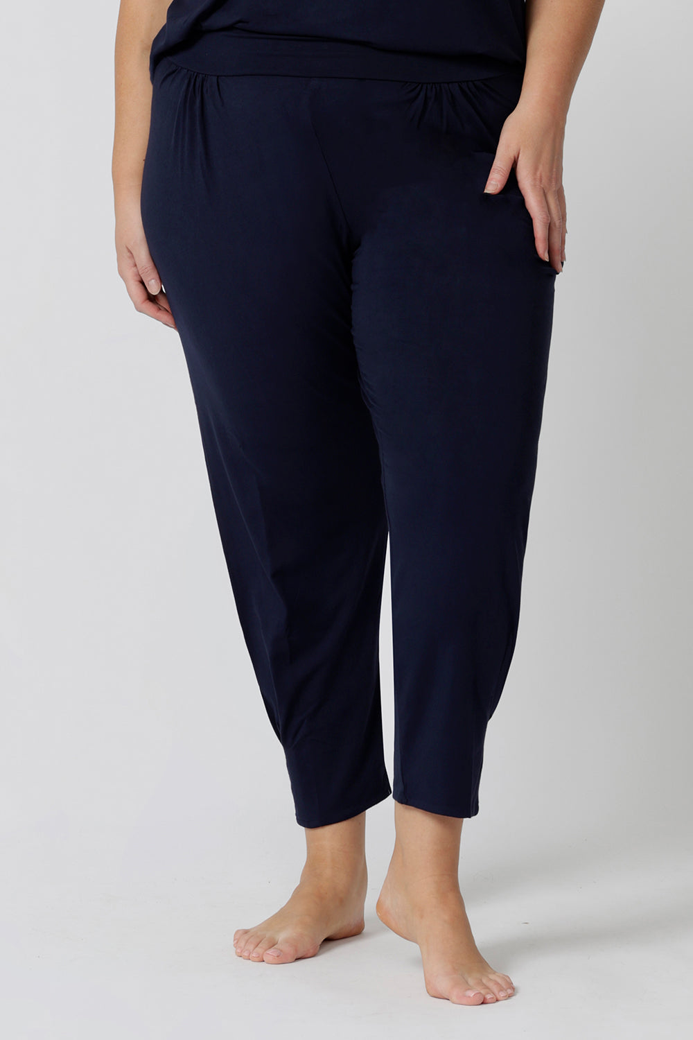 Close up of a good loungewear pant for curvy women. This navy bamboo tapered leg,  plus size pant is a pull-on pyjama pant. Worn with navy bamboo cami top, this is a breathable, thermo-regulating pyjama set and makes get sleepwear for night sweats and hot flushes. Shop loungewear and sleepwear sets online at L&F Australia.