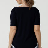 A beautiful and comfortable workwear top for plus size, curvy women, this short sleeve, boat neck top in navy blue is shown on a size 8. A quality top for workwear, this slim fit jersey top is made in Australia by women's clothing brand, Leina & Fleur.