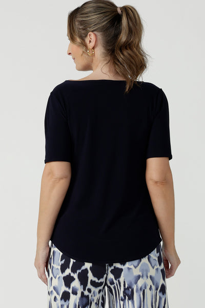 A beautiful and comfortable workwear top for plus size, curvy women, this short sleeve, boat neck top in navy blue is shown on a size 8. A quality top for workwear, this slim fit jersey top is made in Australia by women's clothing brand, Leina & Fleur.