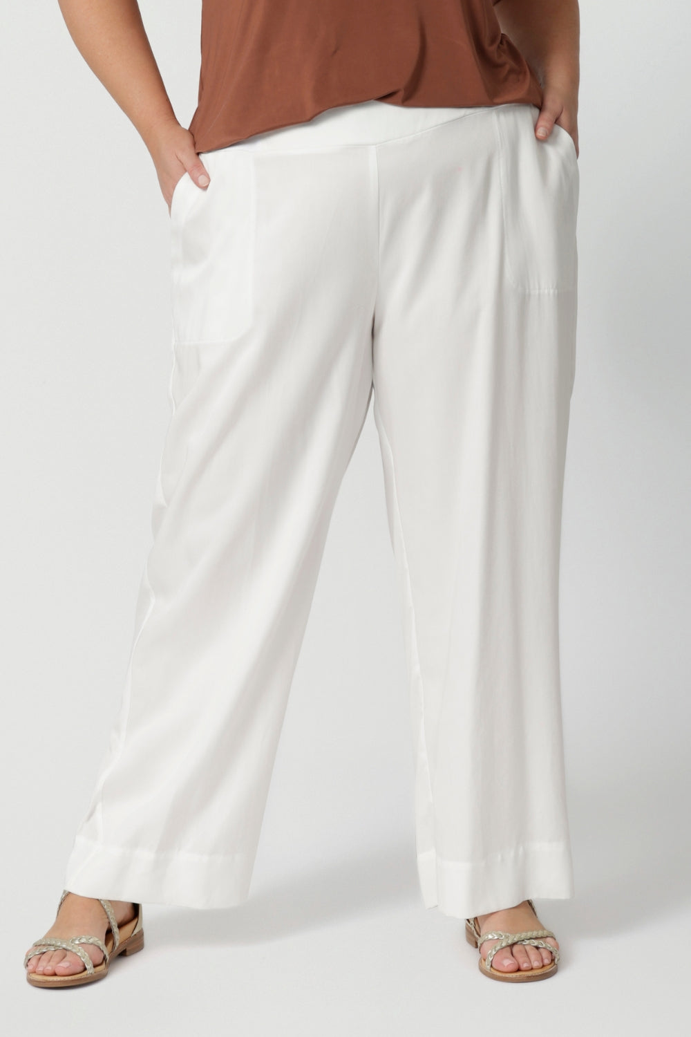 Close up image of a curvy, size 18 woman wearing pull-on, easy care style pants. Resort ready style is comfortable and breathable for everyday wear. Shop these wide leg pants online in sizes 8 to 24. Lyocell fabric designed pants are petite and plus size friendly.