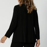 Back view of a 40 year old woman wearing black work wear blazer. Designed for the modern professional woman who values style and functionality. Fashion brand Leina & Fleur currently stocks sizes 8 to 24. Shop this easy-care work blazer in plus size and petite sizes.