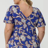 Back view of a good empire line dress for  plus size women, this twist front jersey dress in size 18 has flutter sleeves and a ruffle hem. A blue dress with floral print, be holiday ready with this travel and cruise wear dress style. Made in Australia by Australian and New Zealand women's clothes brand, Leina & Fleur, shop their petite to plus sizes dresses online.