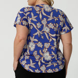 Back view of a summer top for plus size women with flutter sleeves, a curvy size 18 woman shows the relaxed fit of this jersey top. With a holiday print and in lightweight, easy care jersey, this is the perfect top for travel and cruise wear. Made in Australia by Australian and New Zealand women's clothes label, Leina & Fleur shop plus size tops online.