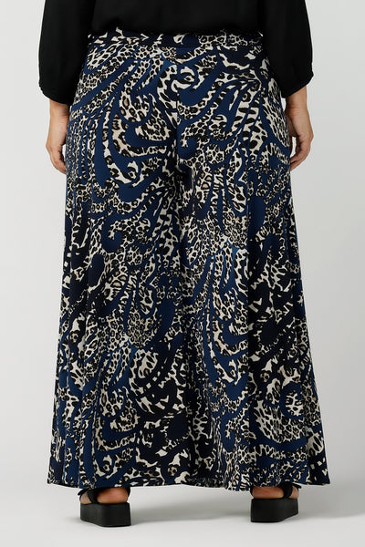 Back view of A curvy, size 16 woman wears animal printed wide leg pants with pockets. These pull-on, easy care pants are comfortable for your everyday capsule wardrobe. Shop these Australian-made wide leg trousers online in sizes 8 to 24, petite to plus sizes.